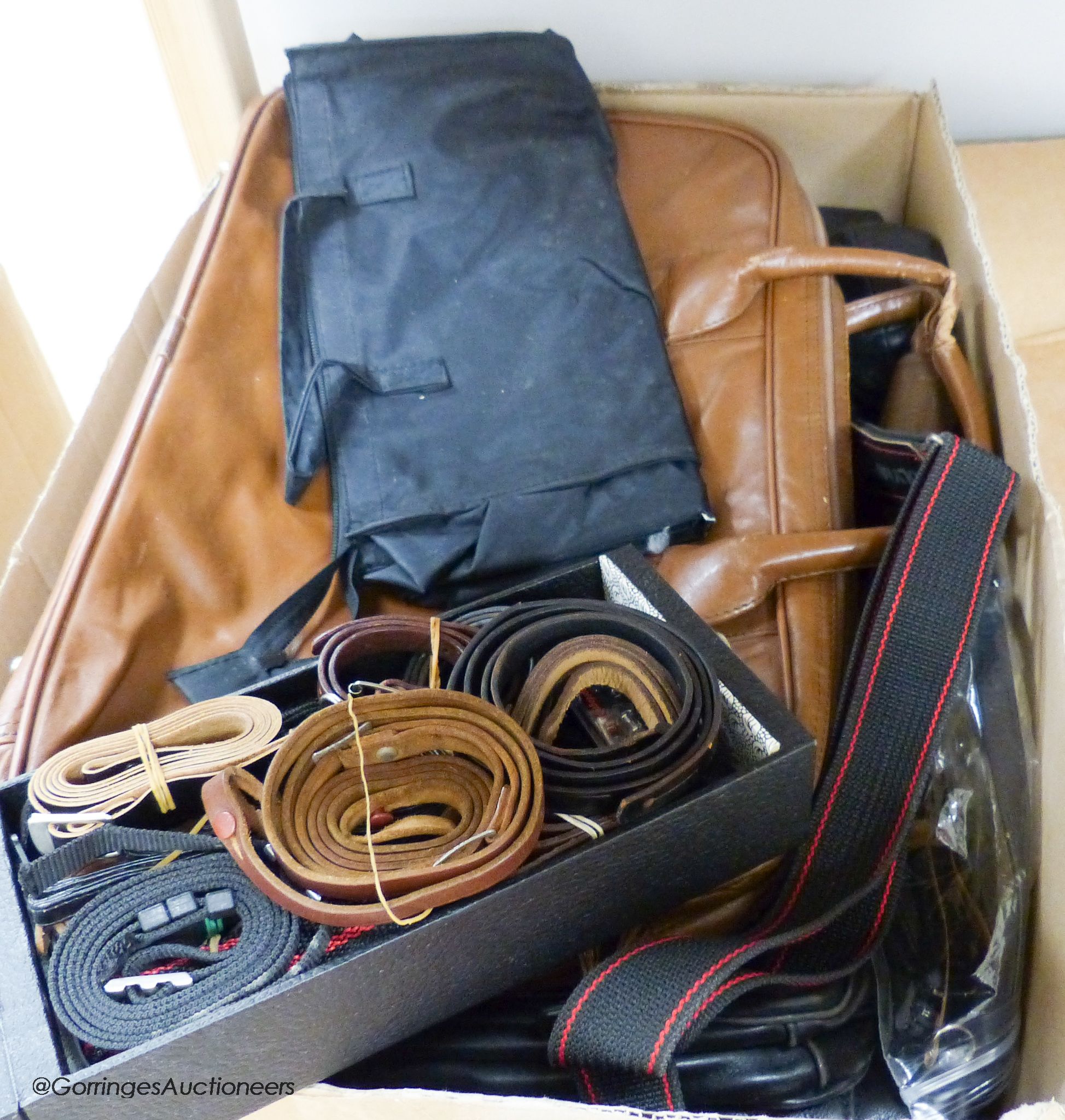 A large collection of leather camera bags, leather camera straps, etc